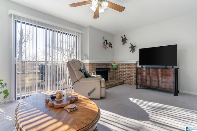 carpeted living room with ceiling fan, a textured ceiling, and a brick fireplace