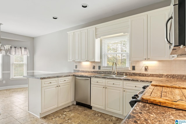 kitchen featuring white cabinets, kitchen peninsula, sink, and tasteful backsplash