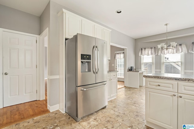 kitchen featuring white cabinets, stainless steel fridge, light hardwood / wood-style floors, and a chandelier