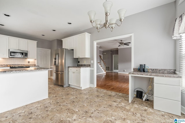 kitchen featuring decorative backsplash, ceiling fan with notable chandelier, stainless steel appliances, light hardwood / wood-style flooring, and white cabinets