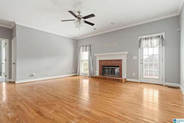 unfurnished living room with crown molding, light hardwood / wood-style flooring, ceiling fan, and a brick fireplace