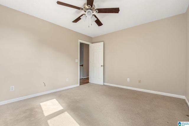 carpeted spare room featuring ceiling fan