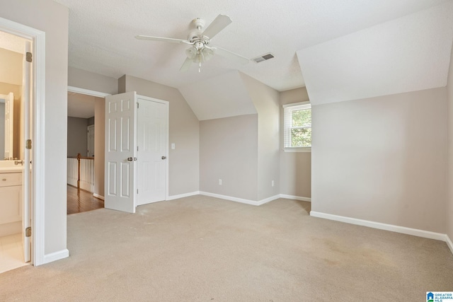 bonus room with ceiling fan, sink, a textured ceiling, vaulted ceiling, and light carpet