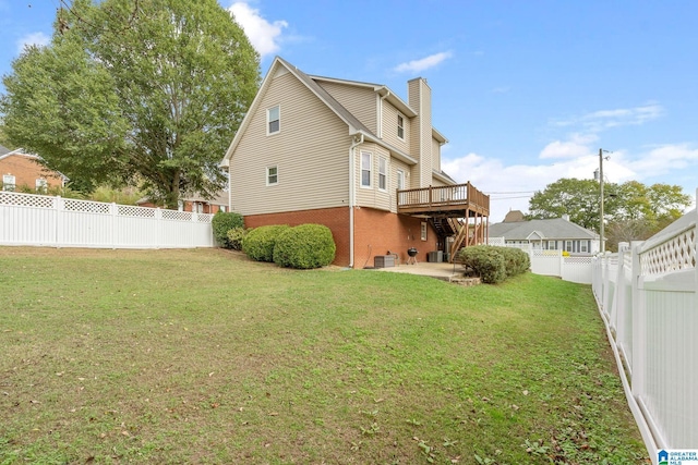 rear view of house featuring a deck, a yard, and a patio