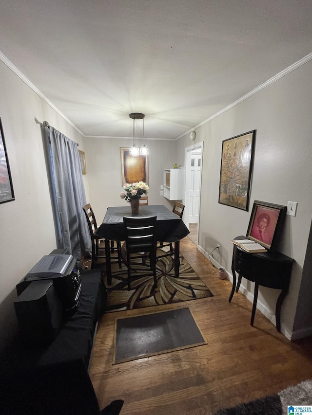 dining room with dark wood-type flooring and crown molding