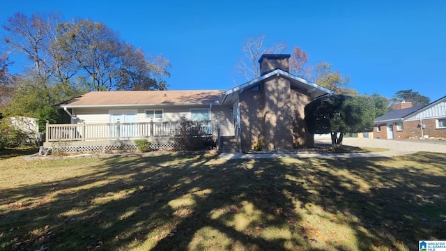 back of property featuring a lawn and a deck