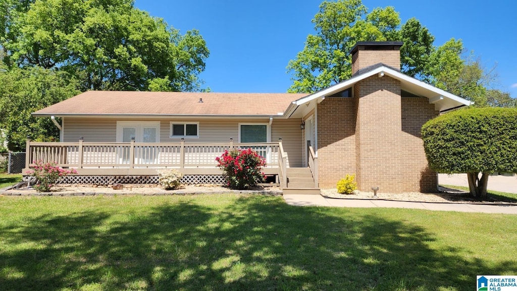 1828 Canyon Rd, Vestavia Hills, AL 35216 - back of house with a wooden deck, a lawn, a chimney, and brick siding