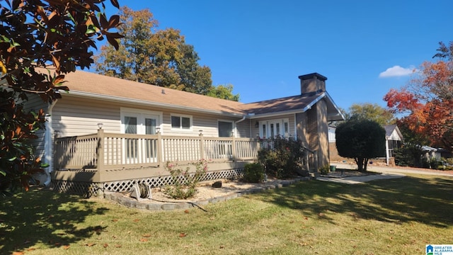 back of property featuring french doors, a yard, and a wooden deck