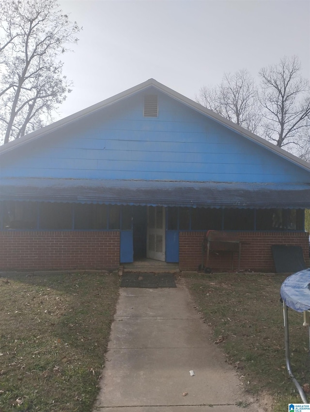 view of front of property with a trampoline and a front yard