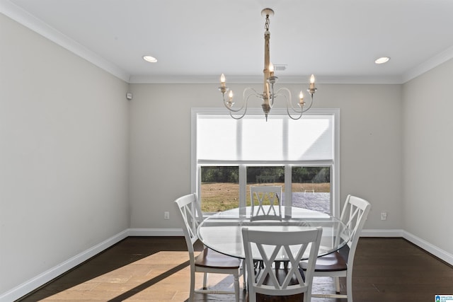 dining room featuring ornamental molding, dark wood-type flooring, and an inviting chandelier