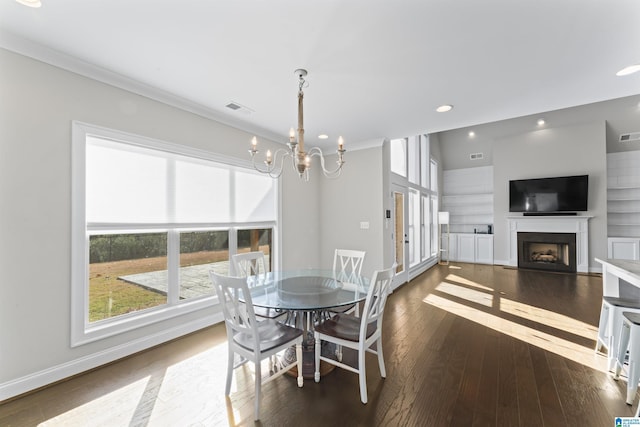 dining space featuring a notable chandelier, crown molding, and dark wood-type flooring