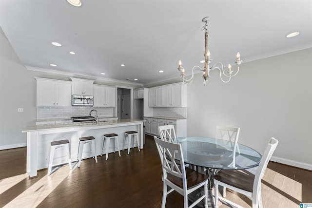 dining room featuring ornamental molding, dark wood-type flooring, and a notable chandelier