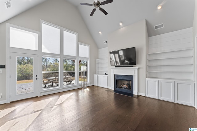 unfurnished living room featuring ceiling fan, hardwood / wood-style floors, high vaulted ceiling, and built in features