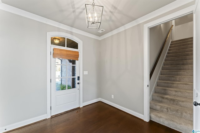 entrance foyer featuring crown molding, dark hardwood / wood-style flooring, and an inviting chandelier