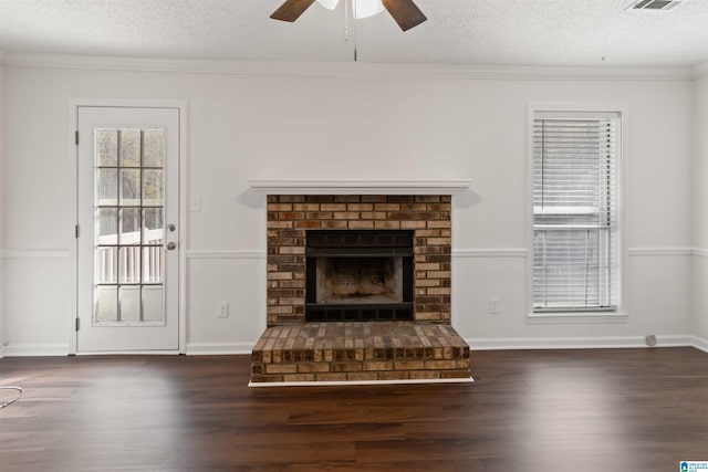 unfurnished living room featuring a brick fireplace, ceiling fan, a textured ceiling, and dark wood-type flooring