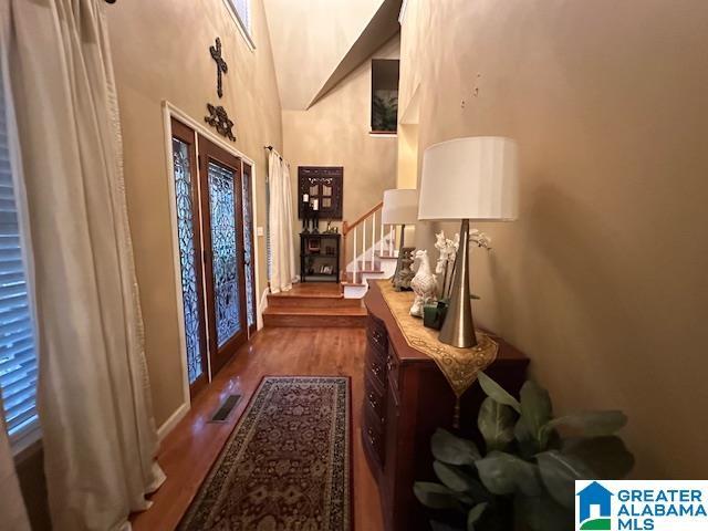 entrance foyer with hardwood / wood-style flooring, a high ceiling, and french doors