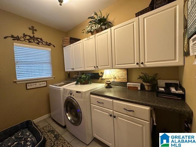 washroom with cabinets, light tile patterned floors, and washing machine and clothes dryer