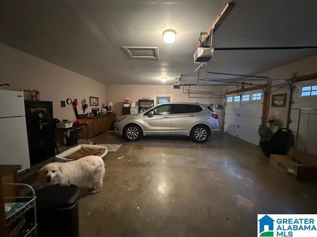 garage with white refrigerator and a garage door opener