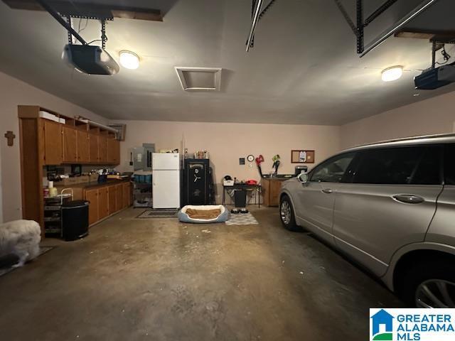 garage with white fridge and a garage door opener