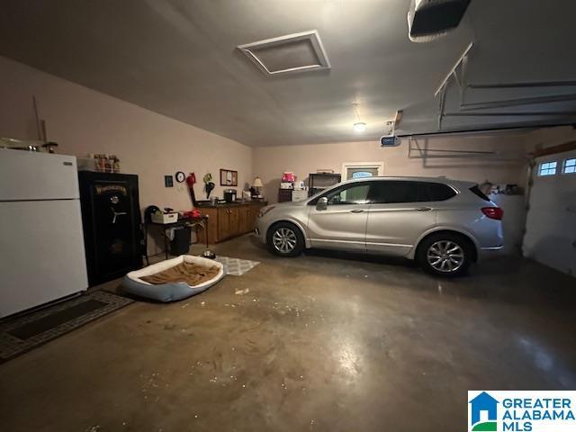 garage with white fridge and a garage door opener