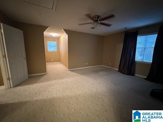 additional living space with light carpet and ceiling fan