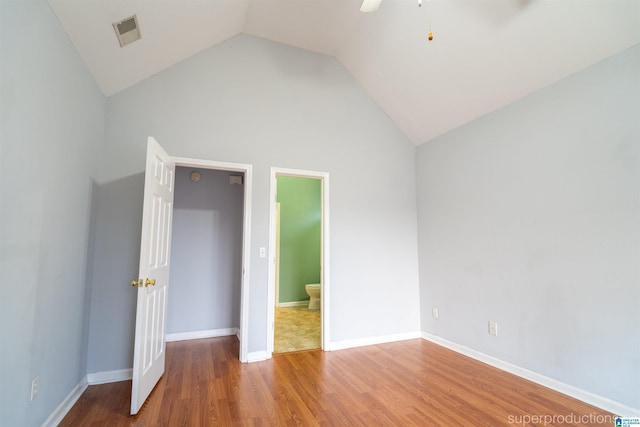 unfurnished bedroom with ceiling fan, ensuite bathroom, high vaulted ceiling, and wood-type flooring