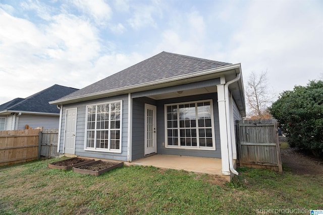 rear view of house featuring a patio area and a yard