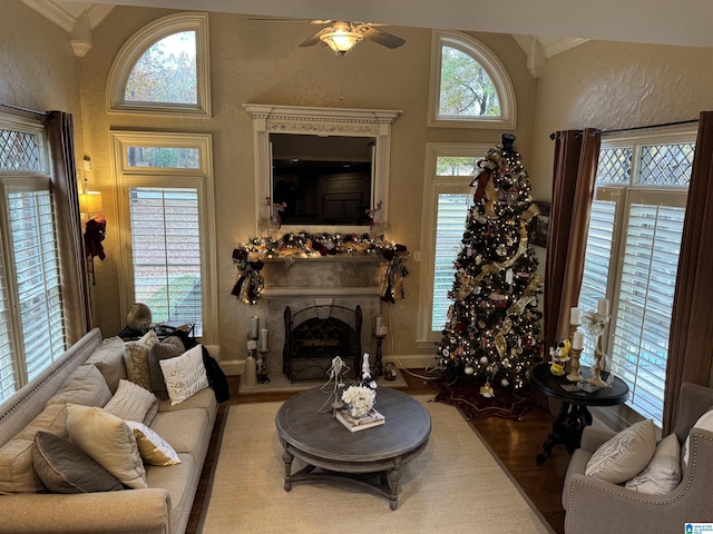 living room with hardwood / wood-style floors, ceiling fan, and ornamental molding