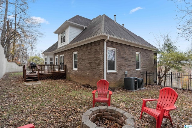 back of house with a deck, an outdoor fire pit, and central air condition unit