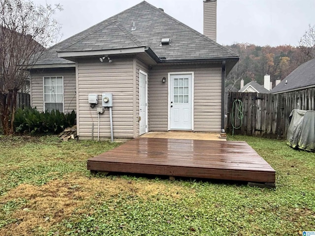 rear view of property with a lawn and a deck