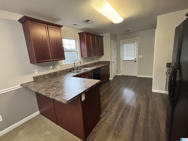 kitchen with kitchen peninsula, dark hardwood / wood-style flooring, black appliances, and sink