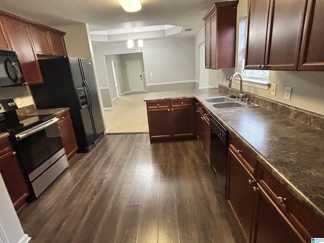 kitchen with sink, decorative light fixtures, dark wood-type flooring, and black appliances