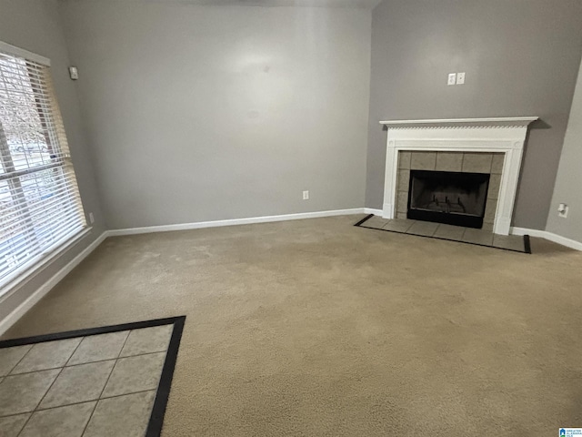 unfurnished living room featuring carpet flooring and a tile fireplace