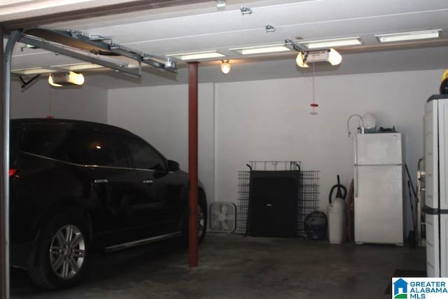 garage with a garage door opener and white refrigerator