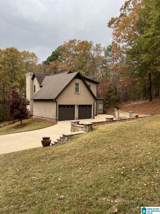 view of property exterior with a garage and a lawn