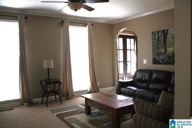 living room with carpet, ceiling fan, and crown molding