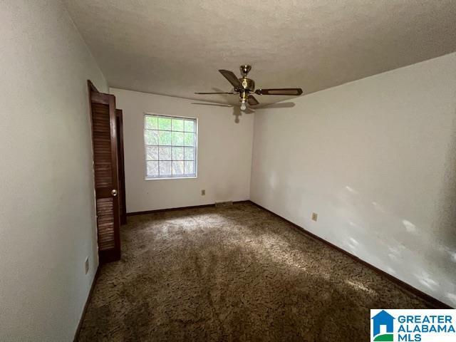 empty room featuring carpet and a textured ceiling