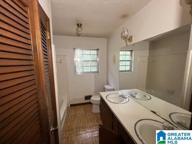 full bathroom with shower / tub combination, vanity, and toilet