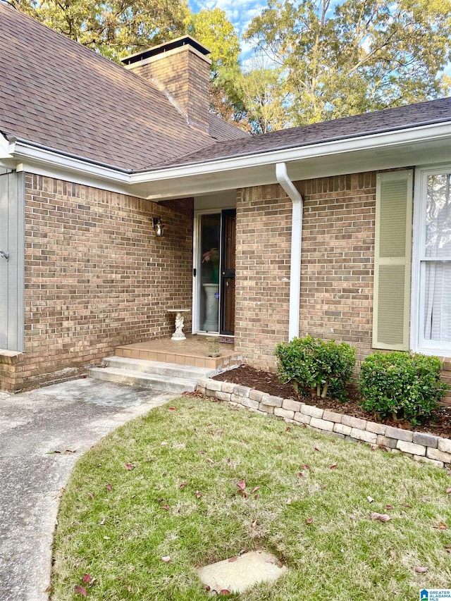 view of exterior entry with a lawn