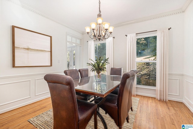 dining room featuring light hardwood / wood-style floors, ornamental molding, and a chandelier