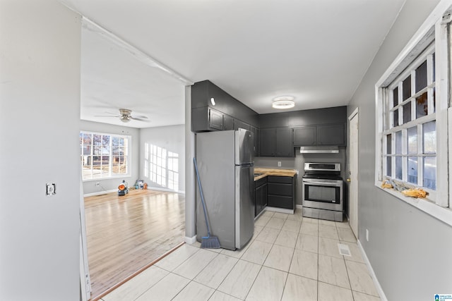 kitchen with appliances with stainless steel finishes, light tile patterned floors, and ceiling fan