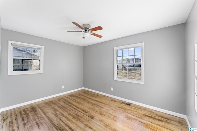 empty room with ceiling fan and hardwood / wood-style flooring