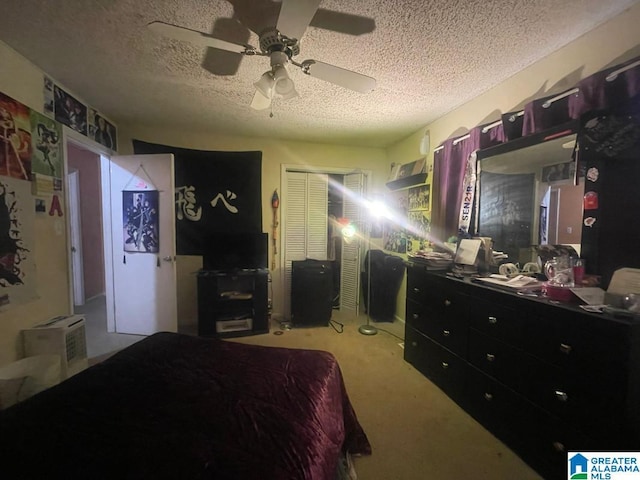 bedroom with ceiling fan, a textured ceiling, light carpet, and a closet