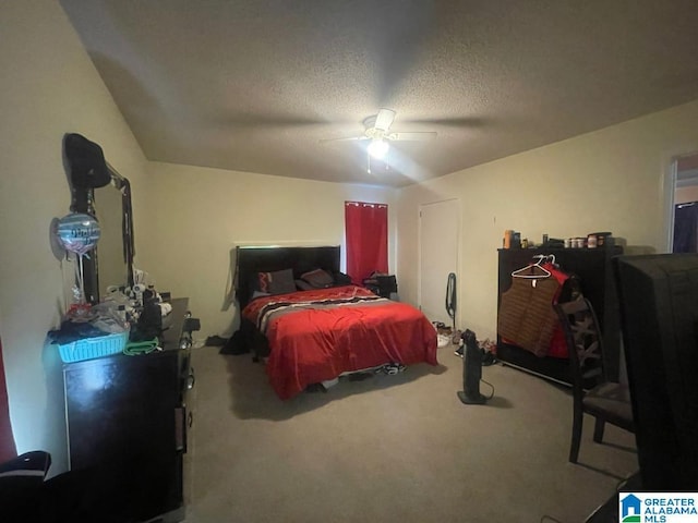 carpeted bedroom with ceiling fan and a textured ceiling