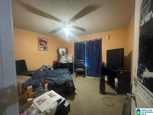 carpeted bedroom featuring ceiling fan and a textured ceiling