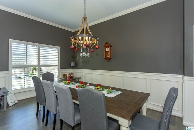 dining space with dark hardwood / wood-style flooring, ornamental molding, and an inviting chandelier