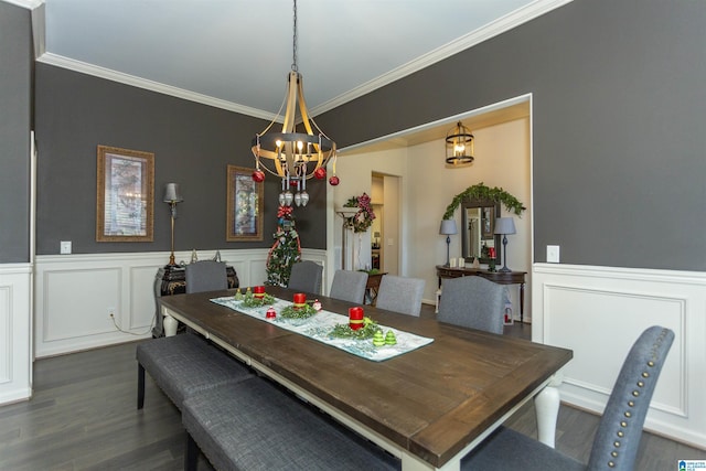 dining area with dark hardwood / wood-style flooring, crown molding, and an inviting chandelier