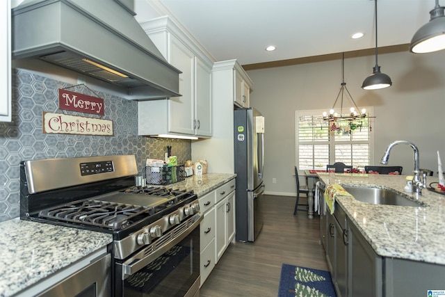 kitchen with light stone counters, custom exhaust hood, stainless steel appliances, pendant lighting, and white cabinetry