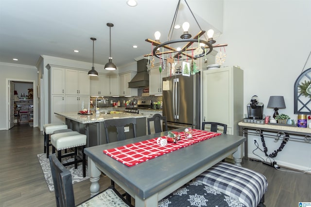 dining area featuring crown molding, sink, a chandelier, and dark hardwood / wood-style floors