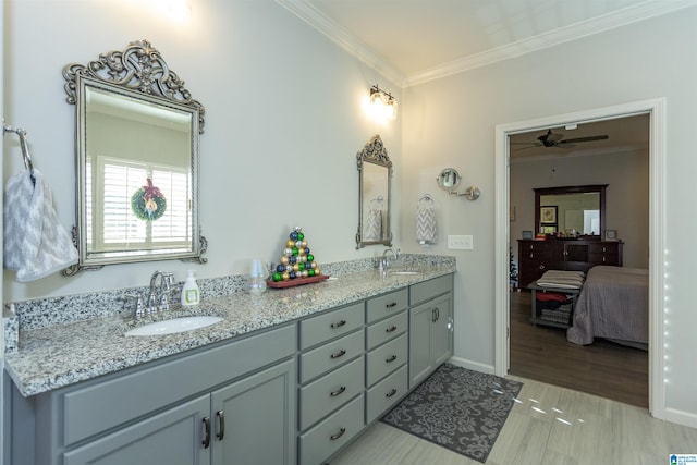 bathroom with ceiling fan, vanity, ornamental molding, and hardwood / wood-style flooring